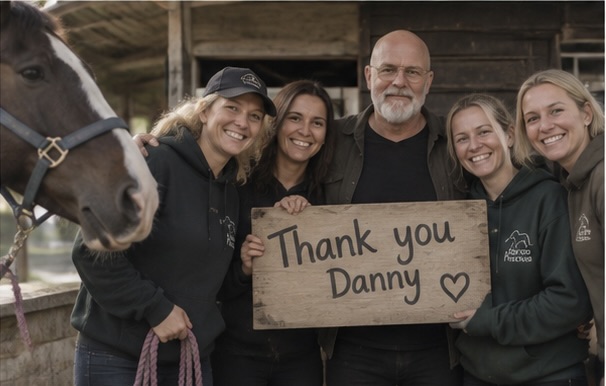 Emilio and an equine rescue team holding a thank-you sign beside a horse